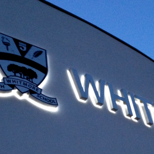 School logo back-lit with LEDs at night